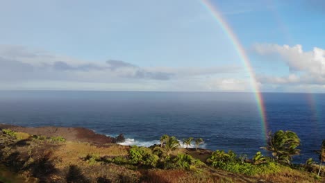 rising up in front of two rainbows over the pacific ocean