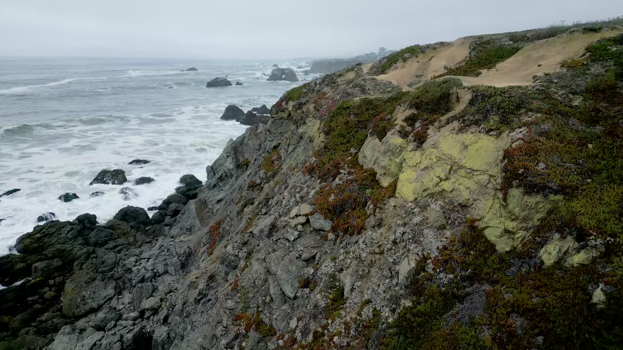 Aerial view over sea cliffs as waves crash on the shore Goat Rock beach, Bodega Bay California