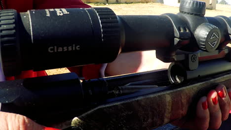 close up of rifle round being loaded into the chamber by a lady, the round jams