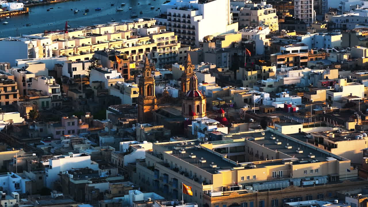 몰타의 슬리마에 있는 빛에 빛나는 파로차 산트와르주 마르 타스-사크로 쿠어 (tas-sacro cuor) 를 둘러싸고 있는 드론 촬영