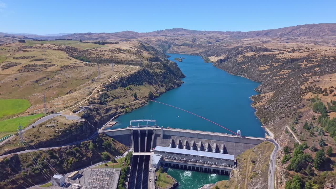Backward drone flight reveals Roxburgh Dam on the Clutha River, a key hydroelectric station in Central Otago, New Zealand