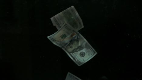 falling flying american canadian dollar banknotes on a black background in 4k loopable. high quality falling dollar banknotes in 4k. video is loopable