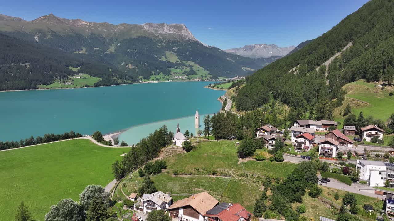 аэроскоп жилого района и спокойного озера возле кампаниле ди курон веноста-веччиа в южном тироле, италия