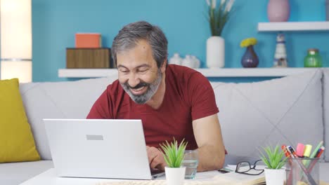hombre de mediana edad feliz con lo que ve en la computadora.