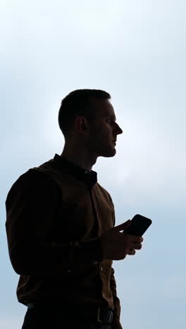 handsome businessman writing notes from smartphone at modern office vertical video