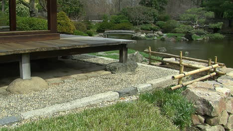 corner of japanese house with gravel drainage apron and pond in background