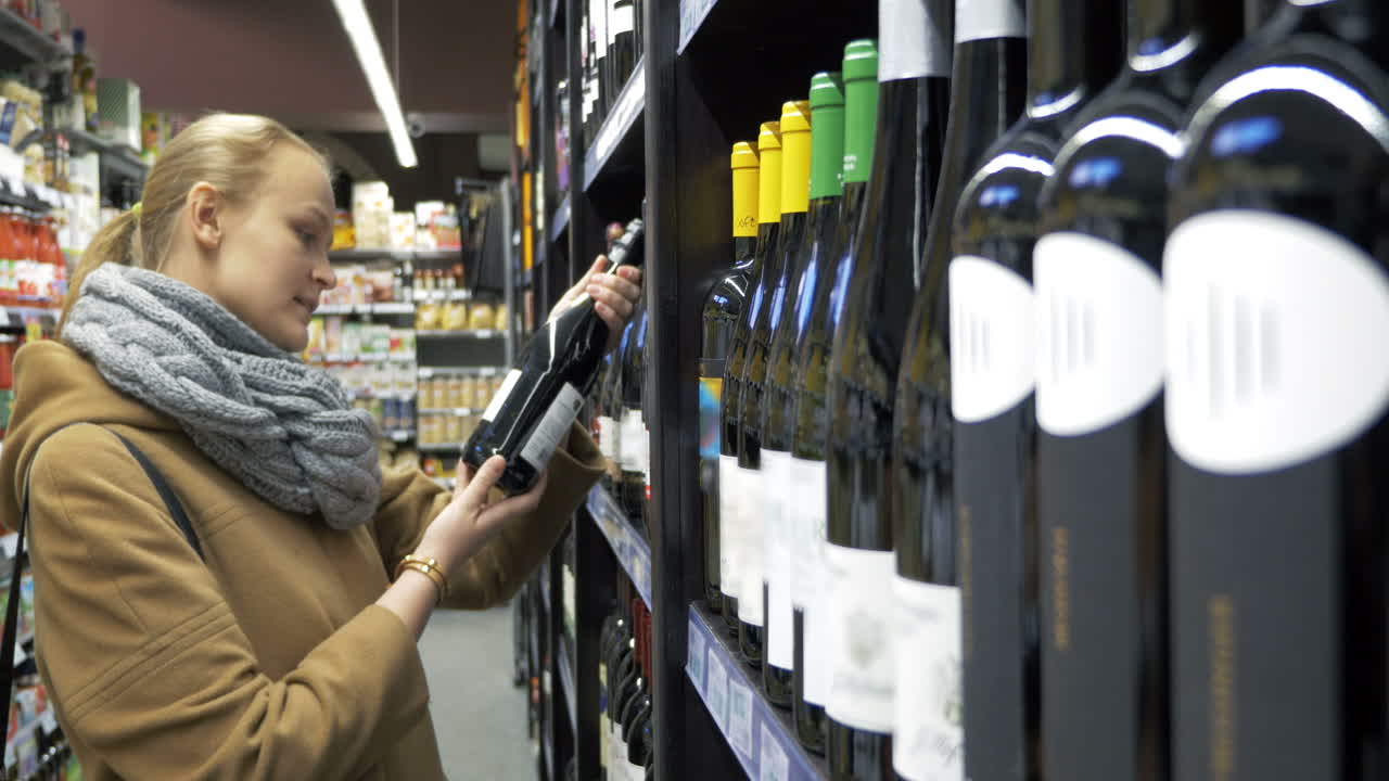 mujer en la tienda eligiendo una botella de vino