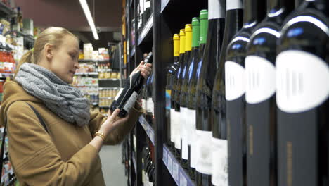 woman in the store choosing bottle of wine