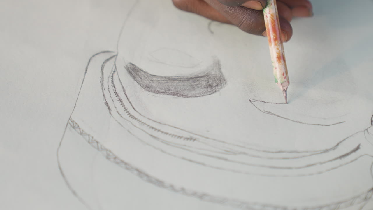 Closeup black hands sketching portrait paper, portrait artist shading eye and brow with graphite pencil, delicate linework on textured sheet, focused studio mood, thoughtful expression emerging