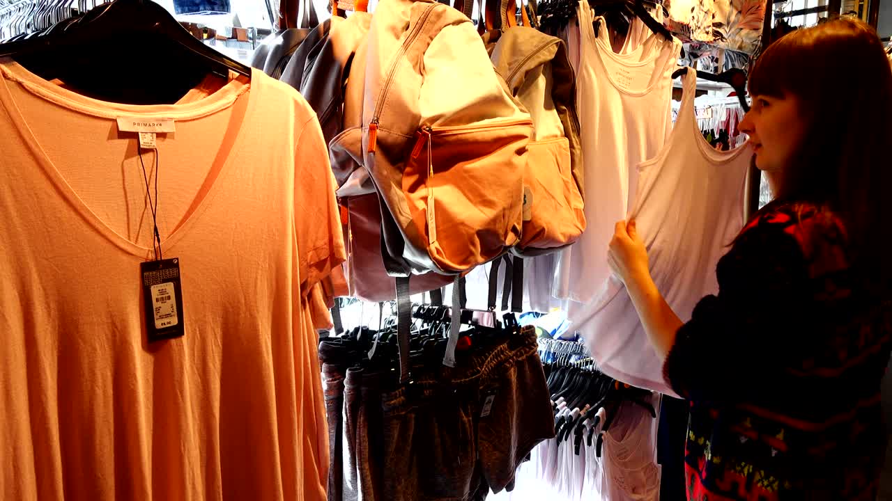 유럽의 쇼핑몰에서 소녀는 옷을 선택합니다.