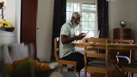 African-american-senior-man-sitting-at-table-paying-bills