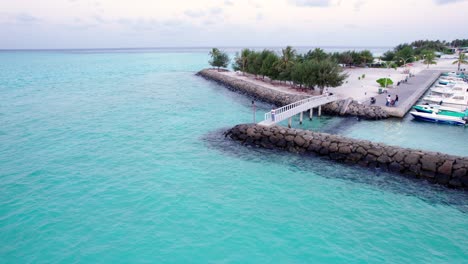 Rückwärtsluftaufnahme-Des-Bootsstegs-Der-Insel-Gaafaru-Am-Abend-Mit-Ruhigen-Meereswellen