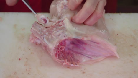 chicken being cut by a butcher