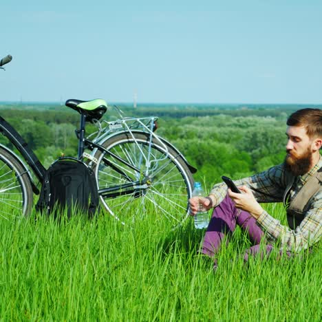 a young man uses a smartphone travels by bicycle 3