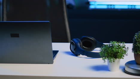 laptop, headphones and mini house plants on table in apartment room