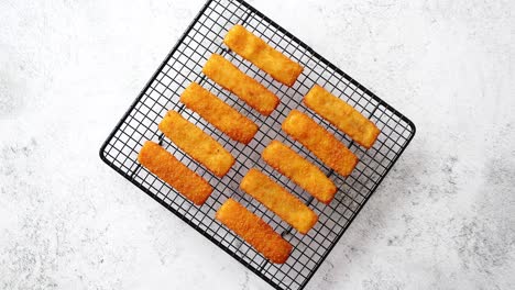 filas de filetes de dedos de pescado fresco frito dorado