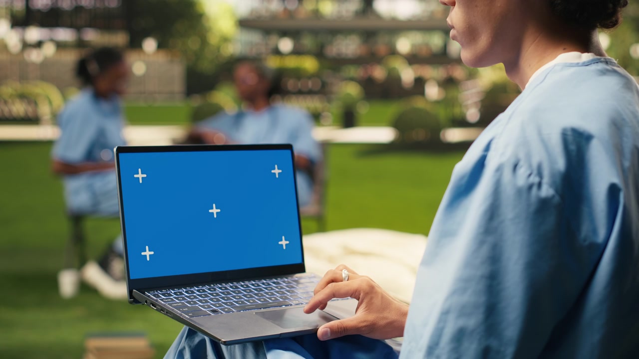 Blue screen laptop mockup held by student using touchpad with one hand