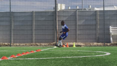 animation of social media icons over african american male soccer player training on sports field