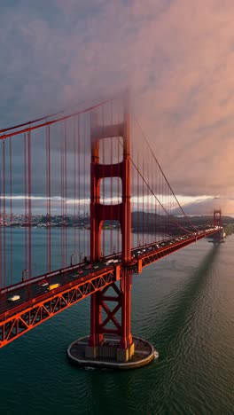 aerial view of the golden gate bridge at sunset, showcasing its iconic red structure against a misty