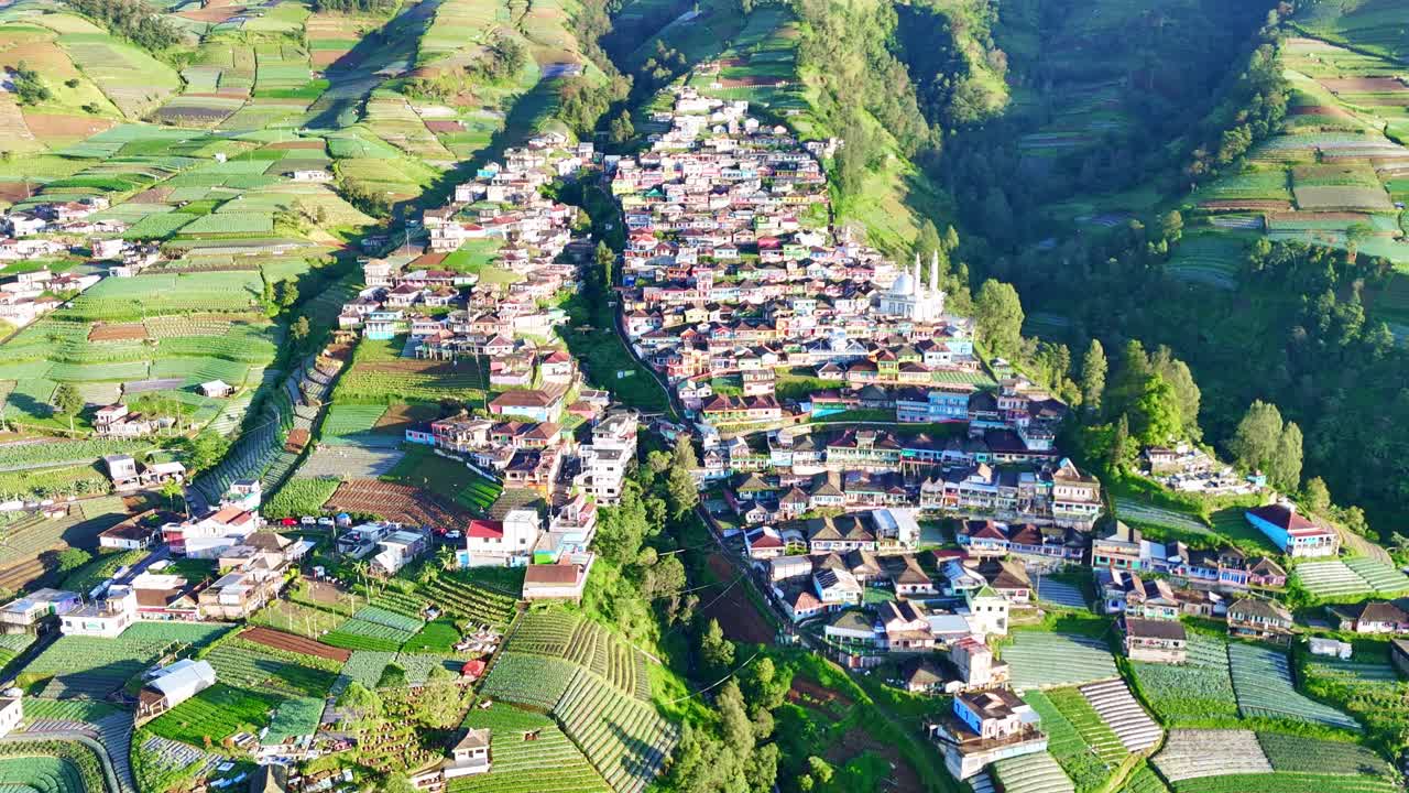 Aerial view of a picturesque mountain village with terraced fields and lush greenery. Nepal Van Java Village, Mount Sumbing, Indonesia