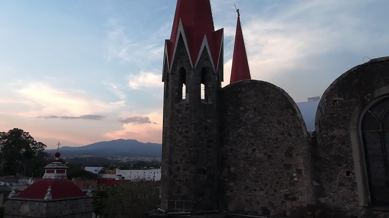Historic church at sunset with red spires in Cuernavaca, peaceful mountain view