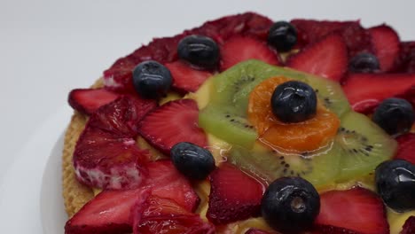 tarta de fruta fresca con fresas, kiwi y naranja, aislado sobre fondo blanco.