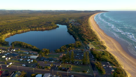 Wide-drone-shot-of-small-pond,-maritime-forest-and-coastline-at-Lennox-Head