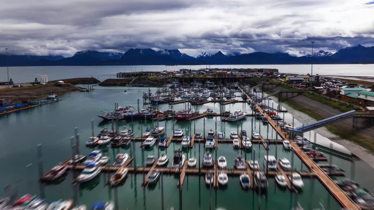 timelapse de hiperlapso de drones aéreos sobre el puerto de una pequeña ciudad en homer alaska al atardecer con barcos de pesca que entran y salen del puerto deportivo y atracan