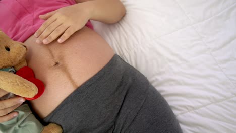 happy pregnant woman sleeping on bed in bedroom.