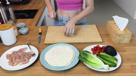 preparing a chicken and veggie wrap