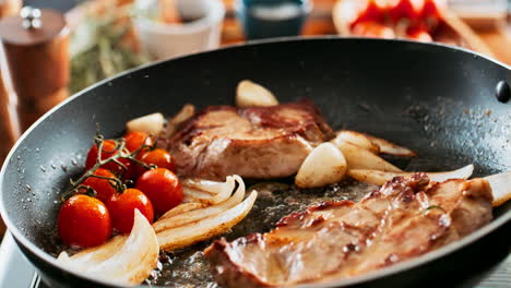 steak with tomatoes and onions in a frying pan