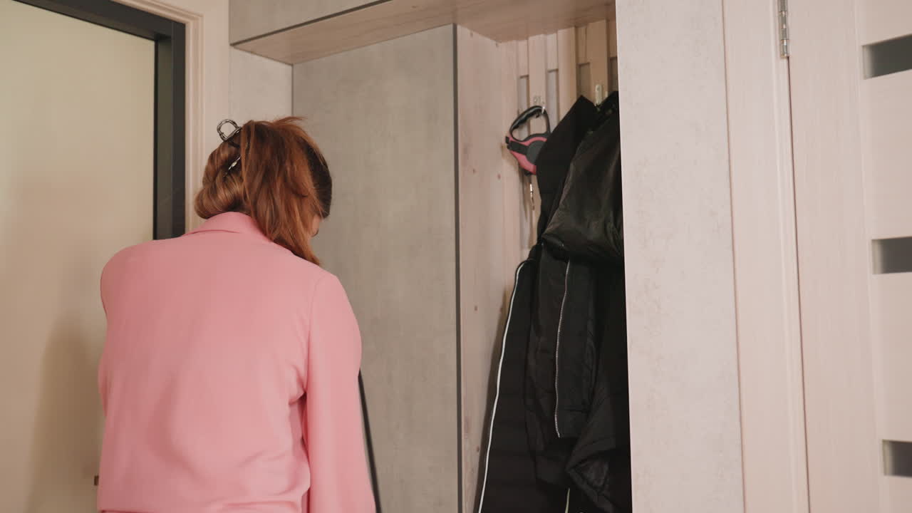 Lady Prepares To Depart, Pinkclad Woman Gathers Belongings Swiftly, She Quickly Grabs Coat And Hanger For Departure, Woman Dressed In Pink Swiftly Retrieves Coat And Hanger To Leave
