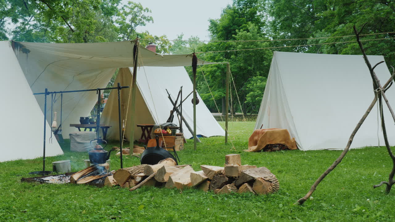전경에 있는 캠프장 음식이 준비되는 모닥불은 오래된 군인 캠프를 모방한 것입니다.