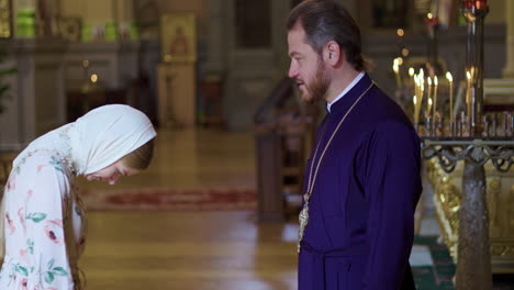Woman kissing priest&#039;s hand