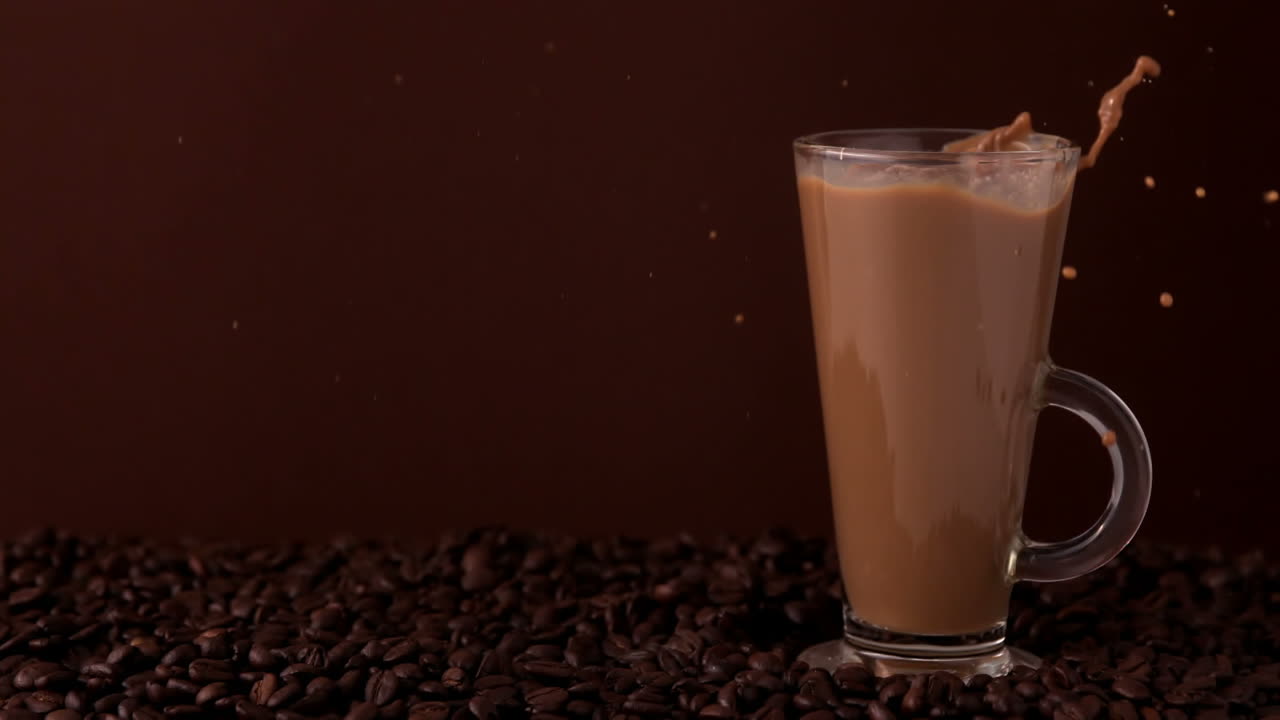Zucchero che si versa in un bicchiere di caffè