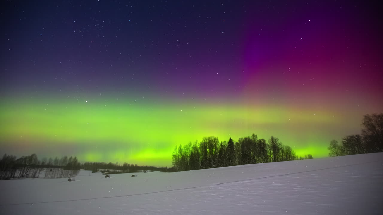 luces verdes y moradas del norte brillando sobre el paisaje invernal - lapso de tiempo de aurora borealis