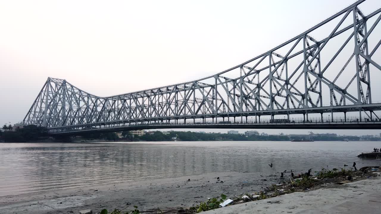 Kolkata, Timelapse of the beautiful Howrah bridge and vintage wooden boats passing beneath it.