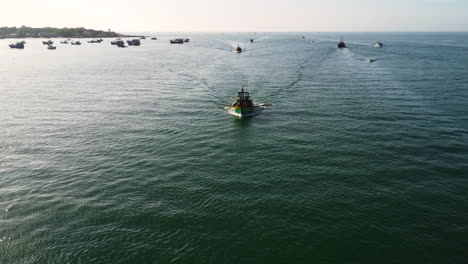 fleet of vietnamese fishing boat heading home after fishing trip in mui ne, aerial view