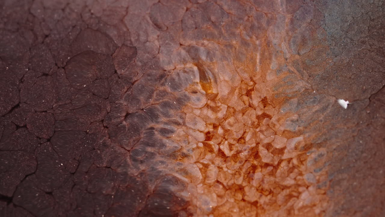 Vibrant red and orange liquids blending together in a mesmerizing abstract macro shot