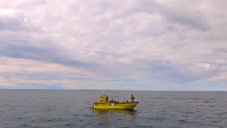 Small-fishing-boat-floating-in-the-middle-of-the-ocean---Aerial-static-shot---wide