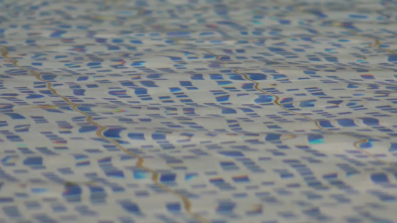 Slow-motion, level view of a swimming pool's rippling surface