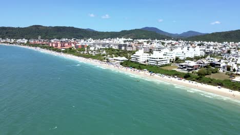 Luftdrohnenszene-Des-Gehobenen-Touristischen-Strandes-In-Florianopolis-Brasilien-Mit-Vielen-Menschen-Am-Strand-Und-Gebäuden-Vor-Dem-Meer-Mit-Wunderschönem-Blauem-Ozean-Jurere-Internacional