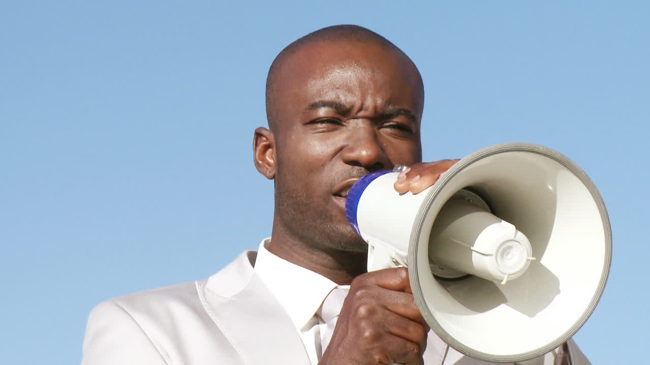 un hombre de negocios exitoso dando reuniones informativas por megáfono.