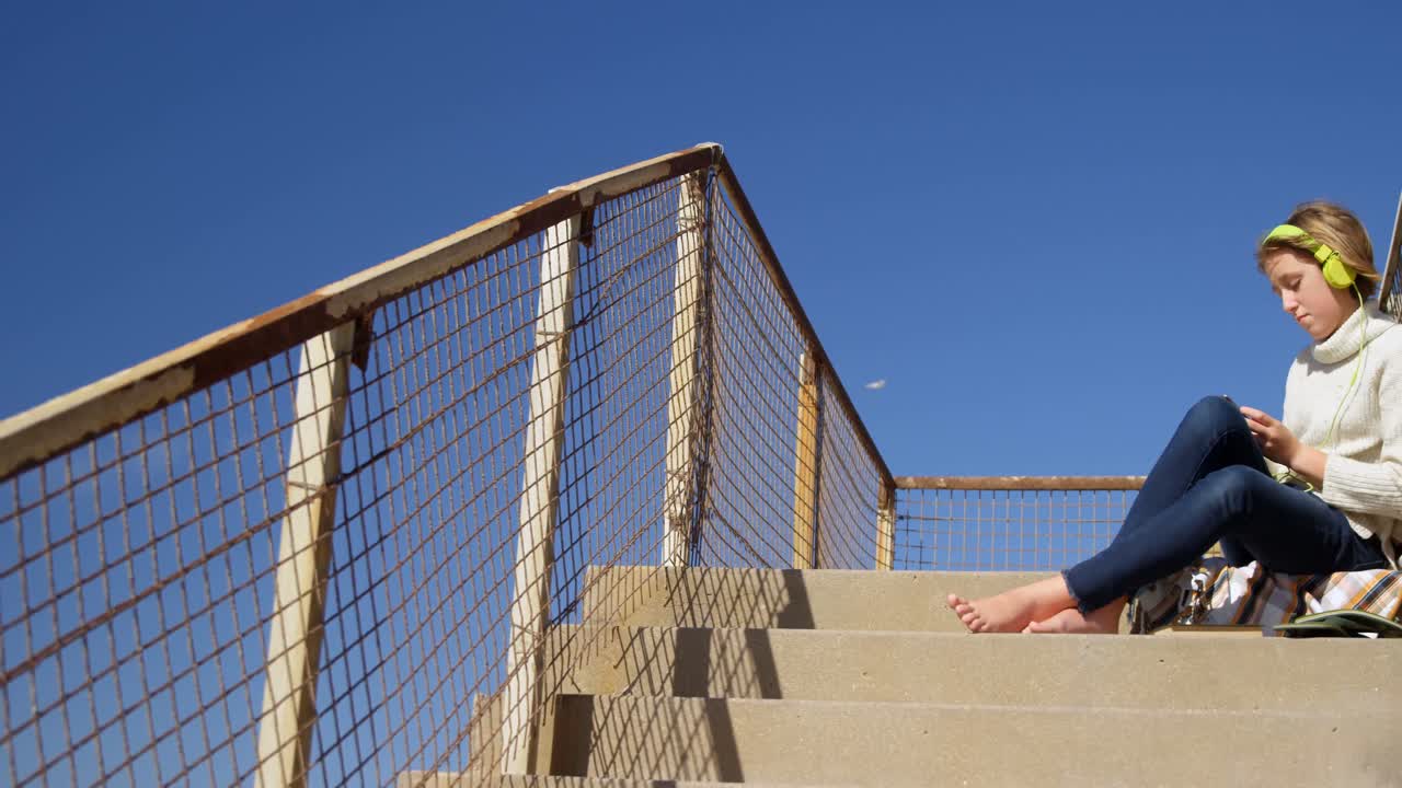 Girl using mobile phone near beach 4k