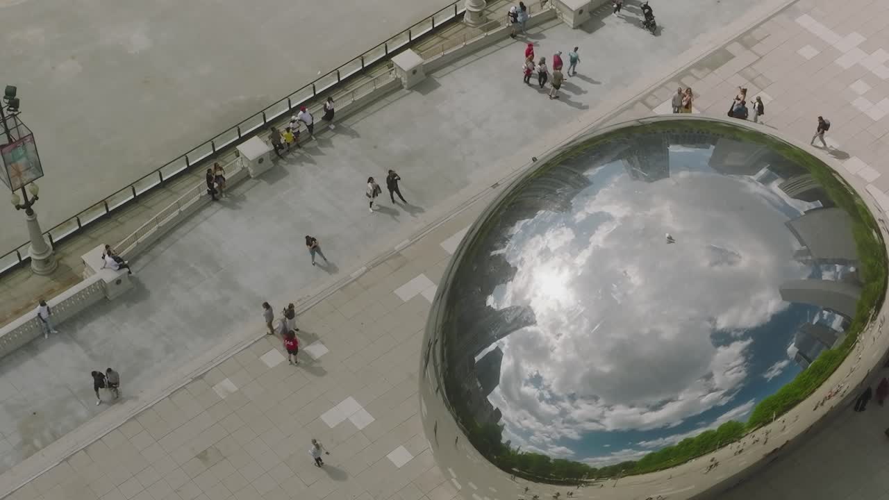 View of Chicago parks and people near a reflective sculpture in summer