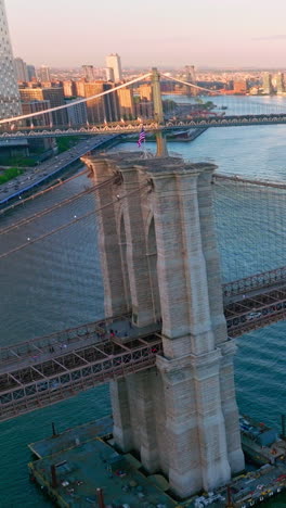 brooklyn and manhattan bridges over east river in new york. sunlit cityscape at the background. aerial view. vertical video
