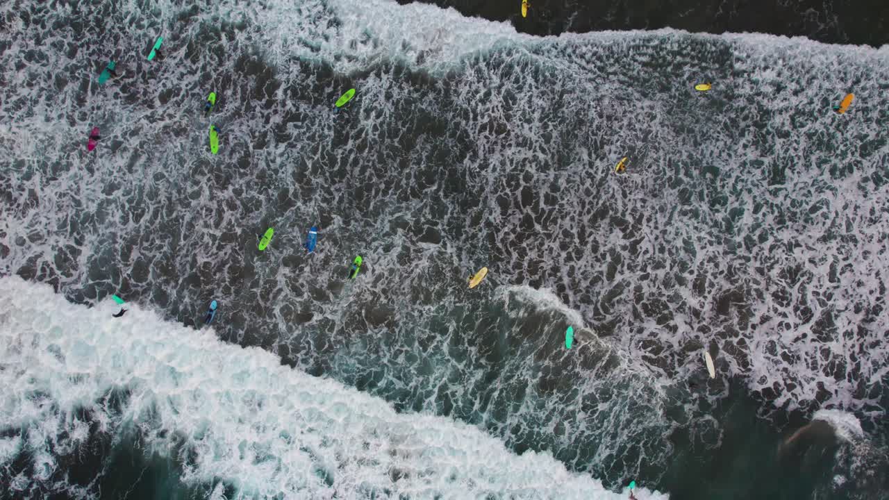 라스 팔마스 데 그란 카나리아의 라스 칸테라스 해변에서 서퍼들이 물 속으로 들어가는 영화적인 위에서 내려오는 항공 사진, 항공기, 드론