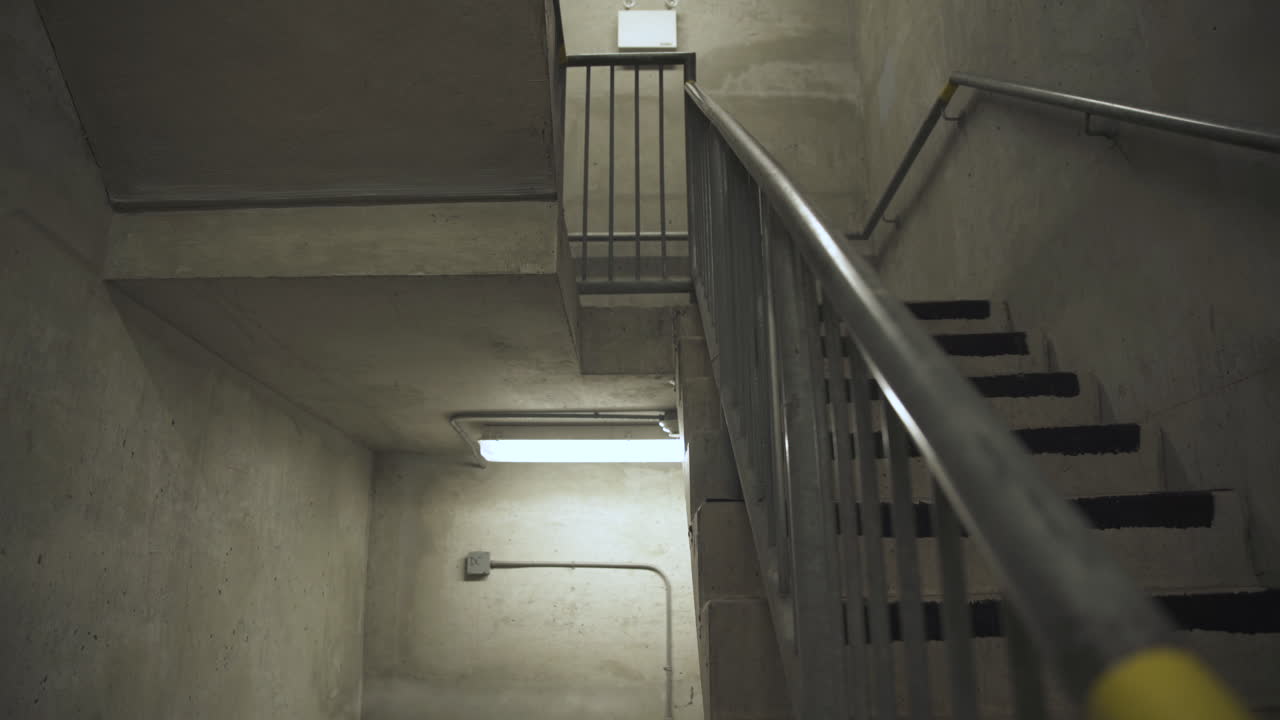 Changement de mise au point sur une rampe dans une cage d'escalier industrielle.