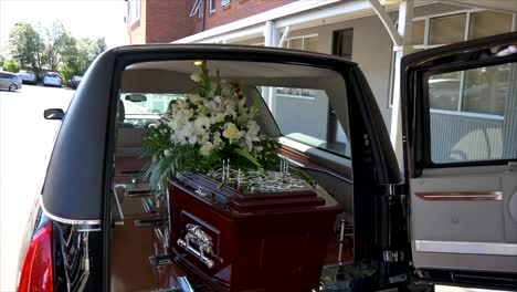 closeup shot of a funeral casket in a hearse or chapel or burial at cemetery