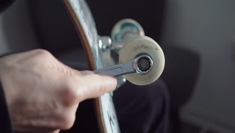 Caucasian-hands-handling-a-wrench-on-a-skateboard